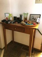 Wooden entry table with vases, framed pictures, and decorative tray on top