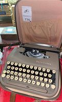 Front angle of Smith Corona Skyriter typewriter inside its carrying case showing keyboard and brand name