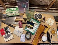 Overview of lot showing assorted vintage bar and kitchen items, games, coasters, knives, incense, and collectables
