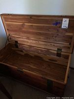 Open vintage wooden blanket chest showing smooth interior and wood grain.