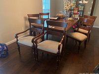 Overall view of dining chairs arranged around a table showing two armchairs and four armless chairs