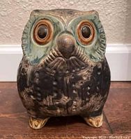 Front view of ceramic owl figurine showing detailed eyes and feather texture.
