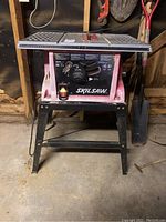 Front view of SkilSaw table saw model 3310 with black metal stand and red body. Control dial, switch, and name label visible on front.