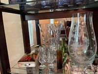 Shelf with crystal floral vase, various stemware, and porcelain bird lidded dish inside original box insert