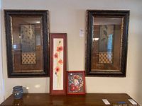 Full view of all five wall art pieces displayed on wall with small blue vase on table below.
