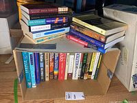 Photo of box of mixed books showing spines including physics and history titles.