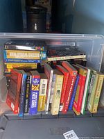 Photo of tote showing assorted books on chess, coins, warfare and other subjects with clear titles on spines and colorful covers.