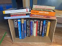Box containing approximately 22 books on a variety of subjects including science, history, and reference materials, clearly visible titles shown on spine facing outward.