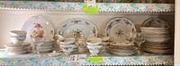 Wide view of the entire china and glassware set arranged on table, showing plates, cups, saucers and glass stemware.