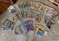 Wide spread of Marvel Comics issues on carpet in protective poly bags