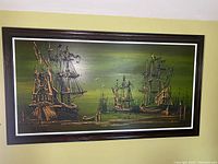 Full view of the framed painting showing detailed relief work on ships.