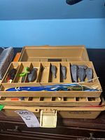 Open tan Old Pal tackle box showing interior fishing lures, lead sinkers, and fishing line organized in compartments