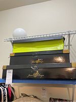 Shelf with boot boxes, including Very Volatile and Joan & Boyce brand boxes.