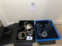 Two Heidi Daus necklace sets displayed in their boxes with necklaces and earrings visible.