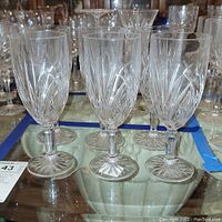 Six Marquis by Waterford iced beverage glasses arranged together showing full set and clear cut patterns on crystal glassware.