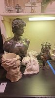 Photo showing entire grouping: large resin bust, resin planter in the shape of a head, two reclining resin female figurines, and part of metal cork holder