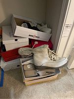 Image showing white fur-lined lace-up ankle boot on top of shoeboxes.