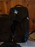 Large black rolling Victorinox duffel bag, open to show interior space and zippered compartments.