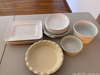 White ceramic serving platters, bowls, pie plate, and ramekins on table