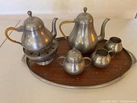 Full view of tea service set displayed on oval tray showing teapots, warming stand, sugar bowl, creamer, and other container