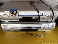 Photo showing two stacked Panasonic VCRs with 4-head Hi-Fi stereo labeling, power buttons, and front loading tape decks.