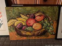 Framed painting of a fruit bowl with bananas, grapes, apples, and plums in warm colors and thick paint texture.