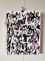 Front view of the abstract painting showing full artwork with layered text strokes in black, white, pink, and gold.