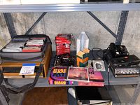 Photo of cassette tape organizer bag with multiple cassette tapes and stacks of cassette tapes in boxes. Includes Sony cassette tape recorder and other audiovisual items on a shelf.