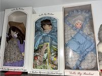 Three dolls in original 'Dolls By Pauline' boxes showing full packaging and dolls inside.