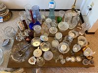 Overview of all items including bowls, vases, candle holders, and salt and pepper shakers placed on a low table.