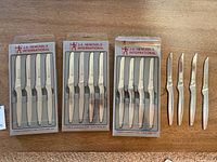Four 4-piece sets of J.A. Henckels International stainless steel steak knives still in packaging plus four loose knives.