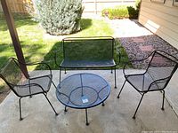 Three-seat set overview showing loveseat, two arm chairs and round coffee table on concrete patio.