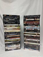 Two stacks of DVDs arranged vertically showing a mix of genres and titles with clear visibility of covers and spines.