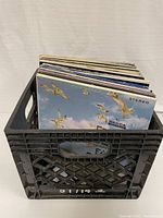 Plastic crate filled with assorted vinyl records, showing front album 'Ebb Tide' by Earl Grant with seagulls and sky artwork.