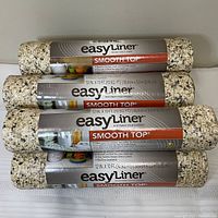 Seven rolled shelf liners stacked horizontally, showing the EasyLiner brand and Smooth Top label.