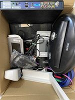 View of box contents showing the Roku device, remote controls, power strip, and other electronic parts