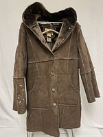 Front view of vintage brown Cherokee patchwork coat with hood, button front, large front pockets, faux fur lining, and embellished sleeves.