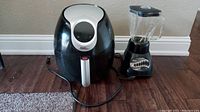 Power XL air fryer and Oster blender side by side showing full units and cords