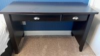 Front view of dark brown wood desk showing both drawers and overall structure.