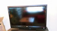 Front view of Vizio flat screen TV turned off, showing full screen and black frame.