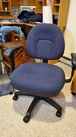 Front view of navy blue office chair showing backrest and padded seat with armrests, on caster wheels.