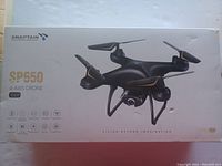 Box with image and branding of SNAPTAIN SP650 4-axis drone, highlighting 1080p camera and features.