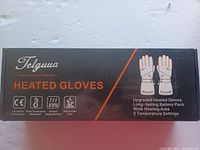 Box packaging showing Telguua brand name and product details including heated gloves with upgraded battery pack, CE safety certification, 3 temperature settings, wind and water proof.