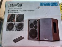 Front of the retail box showing Moukey Bluetooth Bookshelf Speaker model MA20-1 with multiple images of speaker components and remote control.