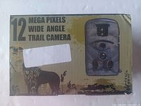 Front of the box showing '12 Mega Pixels Wide Angle Trail Camera' text and photo of the trail camera.