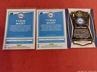 Back of three Tyrese Maxey basketball rookie cards showing text and logos from Philadelphia 76ers and Panini.