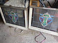 Two stained glass panels side by side in original wood frames, full view