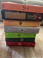 Stack of 7 books from the Diana Gabaldon Outlander series showing spines with titles and author name.
