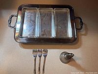 Full view of silver plated serving tray with handles, glass trays inside, three small forks and silver bell.