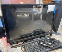 Front view of Acer all-in-one style monitor showing screen and lower bezel with Acer logo. Reflections and partial surroundings visible.